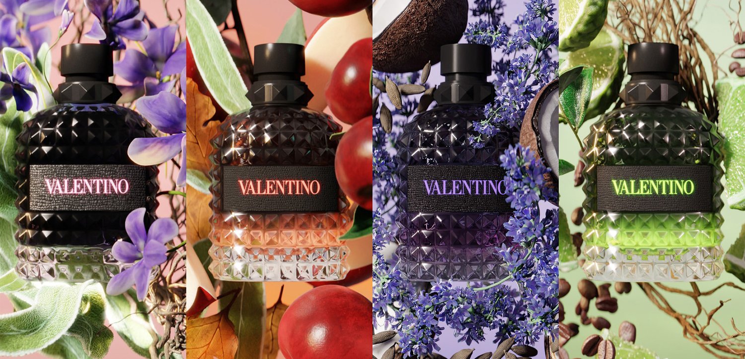 Four Valentino perfume bottles in textured black glass with labels, surrounded by purple flowers, red berries, blue blossoms, and green leaves.