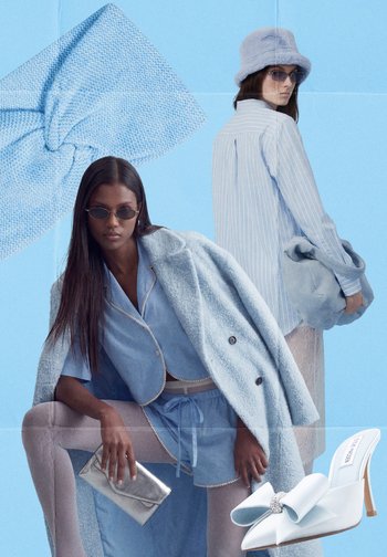 Két nő pasztellkék ruhákban pózol; az egyik egy kabátot, rövidnadrágot és kistáskát viselve guggol, a másik pedig áll, kezében egy puha táskát tartva, kalapot és napszemüveget visel.