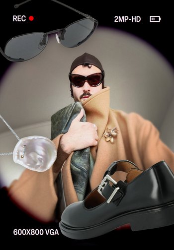 Lunettes de soleil noires, un manteau beige, un châle vert, un collier de perles et des chaussures en cuir noir avec une boucle argentée. Vue axée sur la partie supérieure du corps.