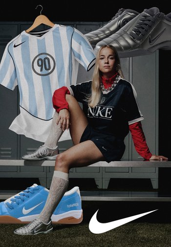 Nike sportswear features a blue and white striped jersey, black top, silver shoes, and knee-high white socks on a girl sitting near lockers.