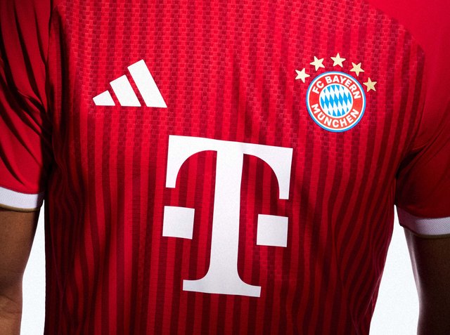 Rotes FC Bayern München Fußballtrikot mit Adidas-Logo auf der linken Seite und großem weißen Telekom-Logo in der Mitte.