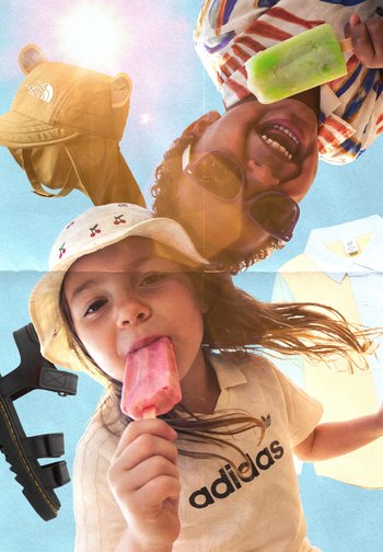 Two children wearing sun hats eat popsicles, set against a blue sky with floating clothing and accessory items around them.