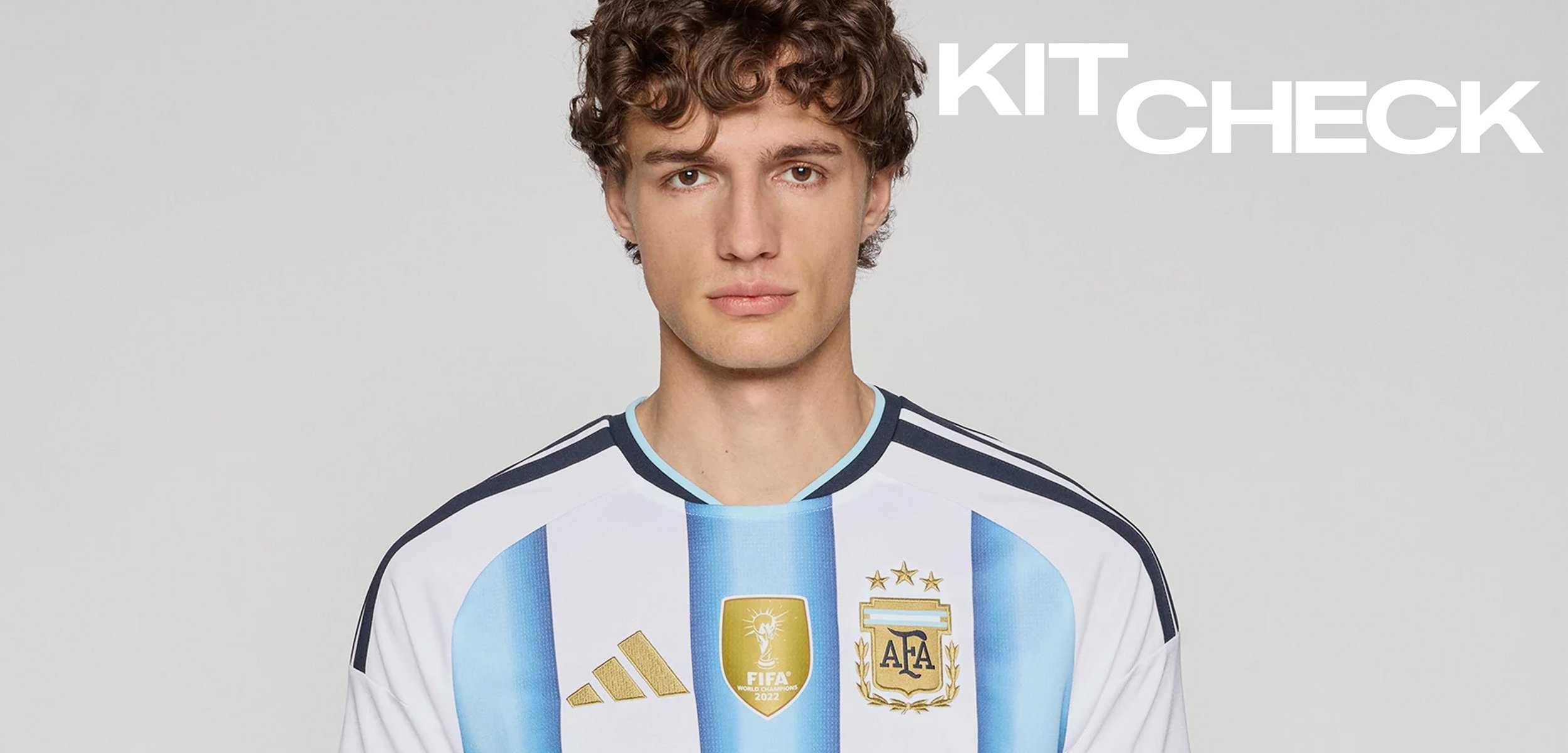 Junger Mann in einem argentinischen Fussballtrikot mit FIFA- und AFA-Abzeichen, stehend vor einem schlichten Hintergrund mit dem Text "KIT CHECK".