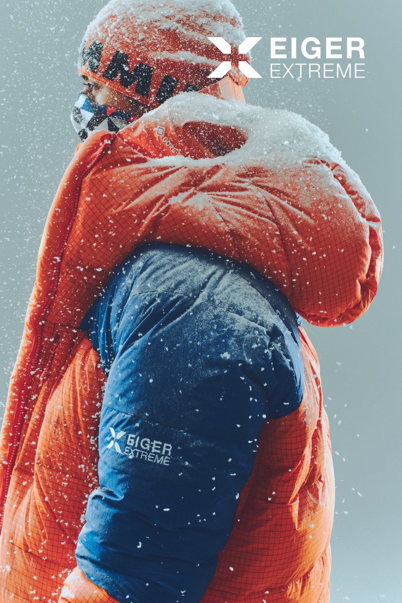 Giacca puffy Eiger Extreme in arancione e blu. Presenta un tessuto testurizzato, protezione dalla neve e logo sulla manica. Adatta per ambienti freddi.