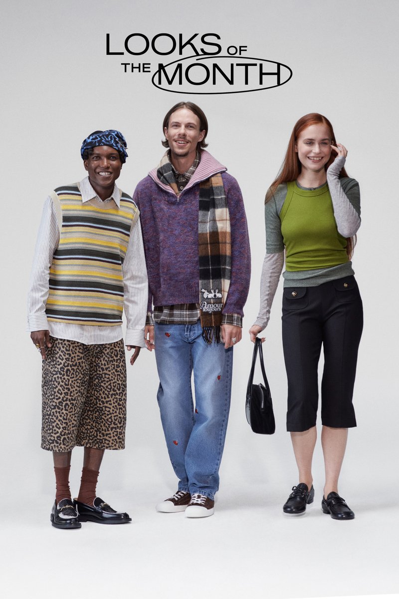 Trois individus se tiennent ensemble. Le premier porte un gilet à rayures sur une chemise à rayures avec un short à imprimé léopard. Le deuxième a un haut en tricot et une écharpe à carreaux. Le troisième arbore un haut vert avec des accents gris et un pantalon noir court, tenant un sac noir.
