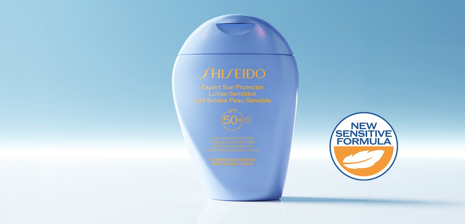 Blue Shiseido Expert Sun Protector Lotion bottle with SPF 50+ and new sensitive formula label on a light blue background.