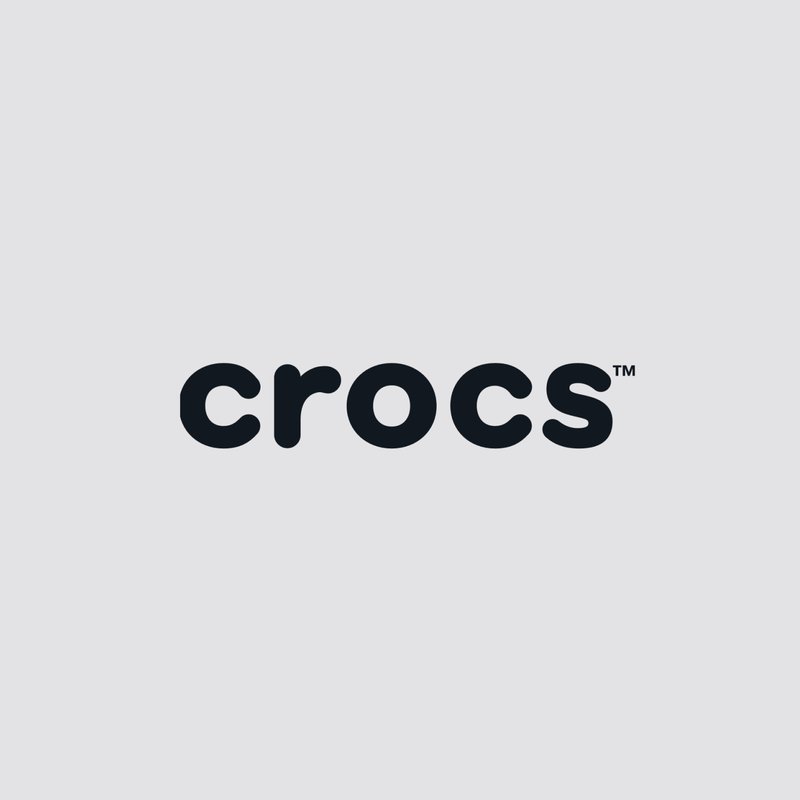 Markenname Crocs in Kleinbuchstaben und schwarzen Buchstaben auf einem hellgrauen Hintergrund mit einem Markenzeichen-Symbol.