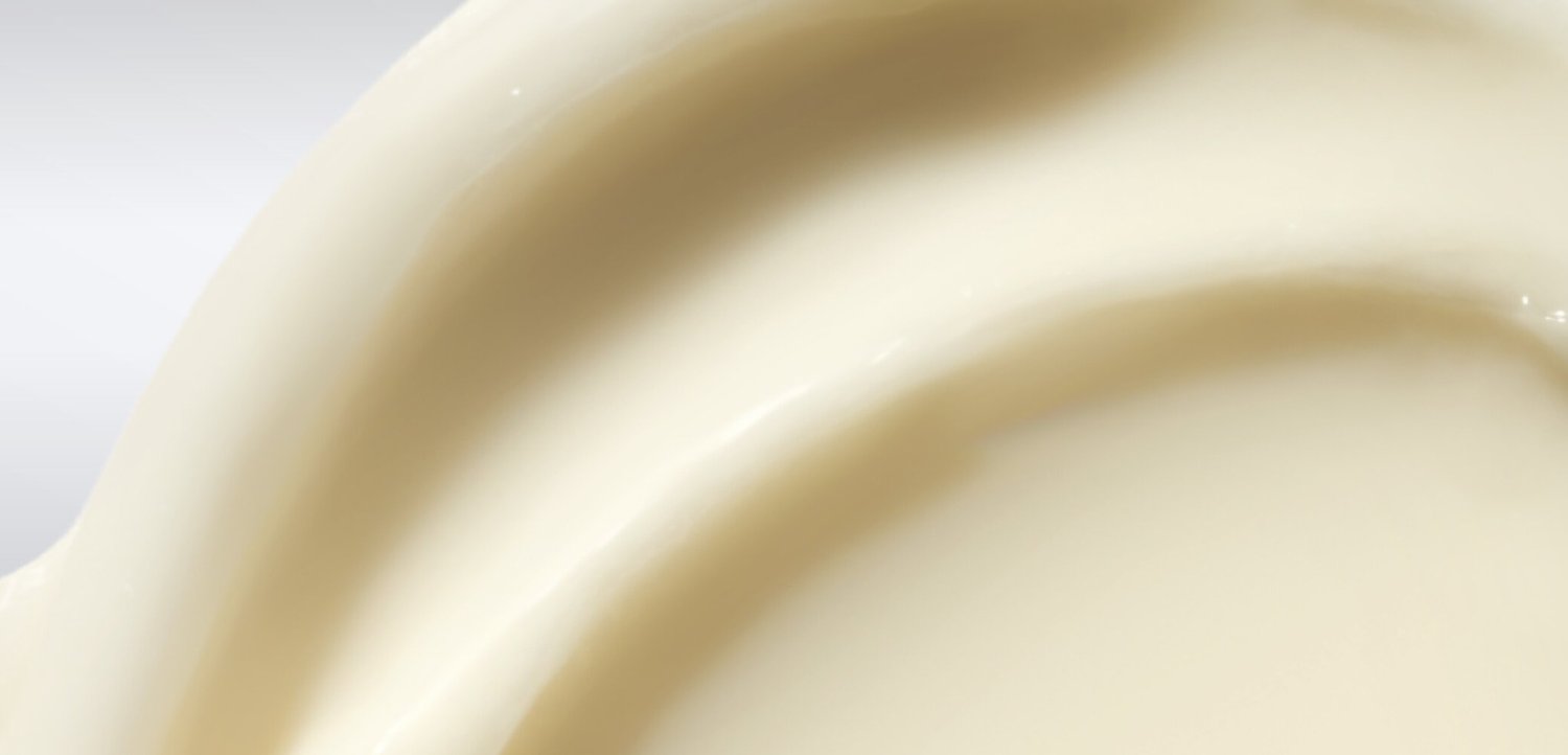 Close-up van glad, romig wit vloeistof die wordt gegoten, met vloeiende textuur en zachte krommen.
