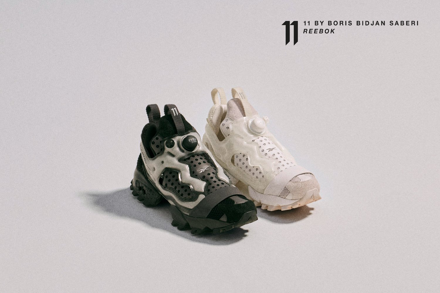 Dos pares de zapatillas Reebok, uno negro y otro blanco, presentadas con diseños y texturas distintas, sobre un fondo claro.