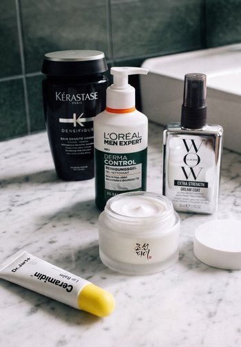 Cinco productos para el cuidado de la piel y el cabello, que incluyen un champú Kérastase, un limpiador L'Oréal, un tratamiento capilar WOW, una crema en un frasco de vidrio y un bálsamo labial Dr. Jart+.