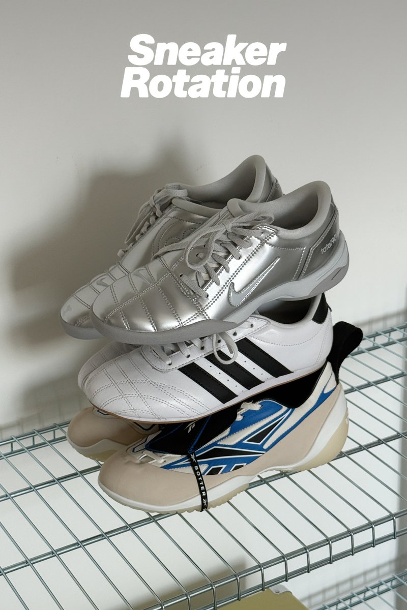 Tre par sportskor staplade på en trådhylla: silverfärgade Nike, vita Adidas med svarta ränder och beige Reebok med blå accenter.