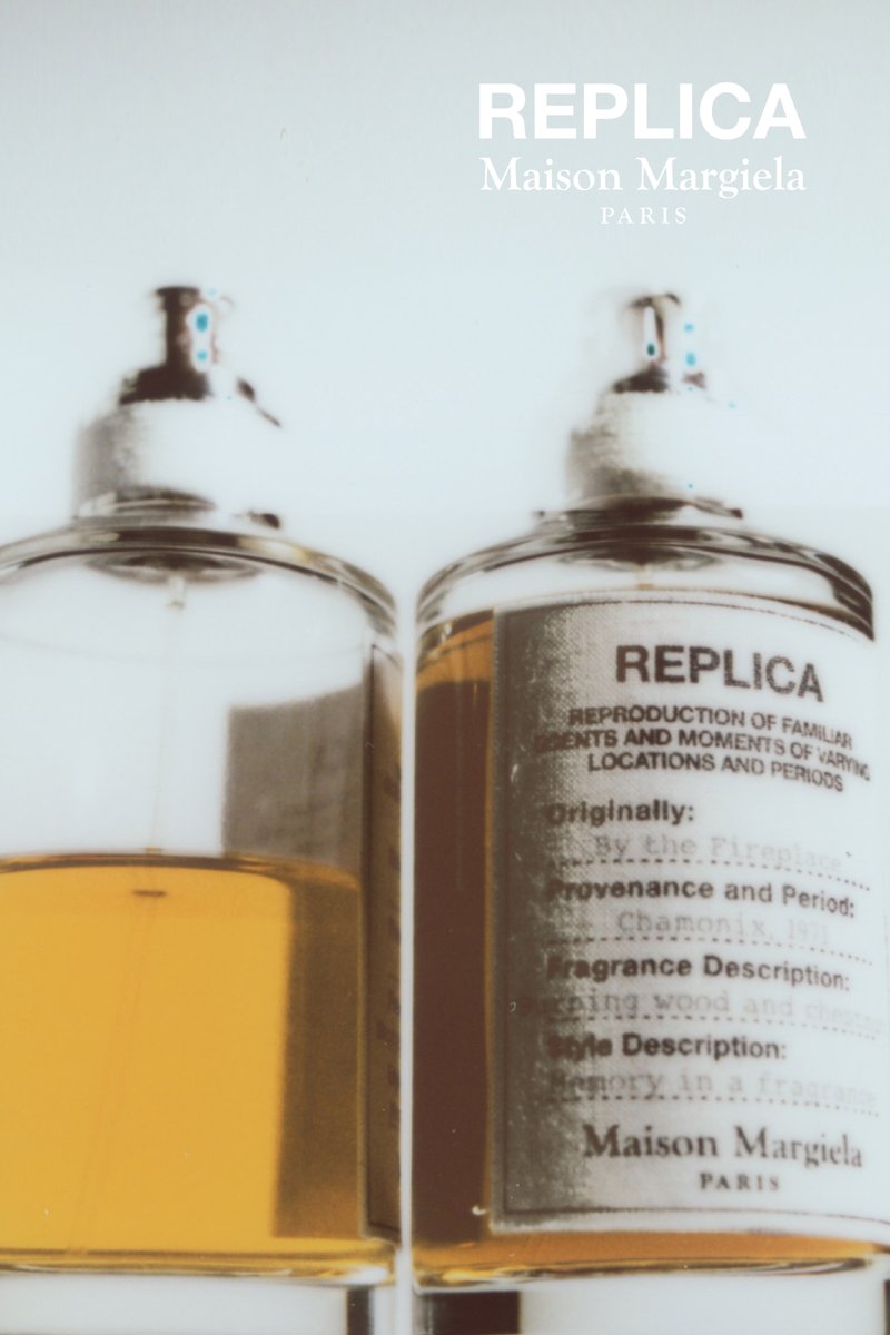 Two clear glass perfume bottles with metallic spray tops, filled with amber liquid. Labels display text about fragrance and description.