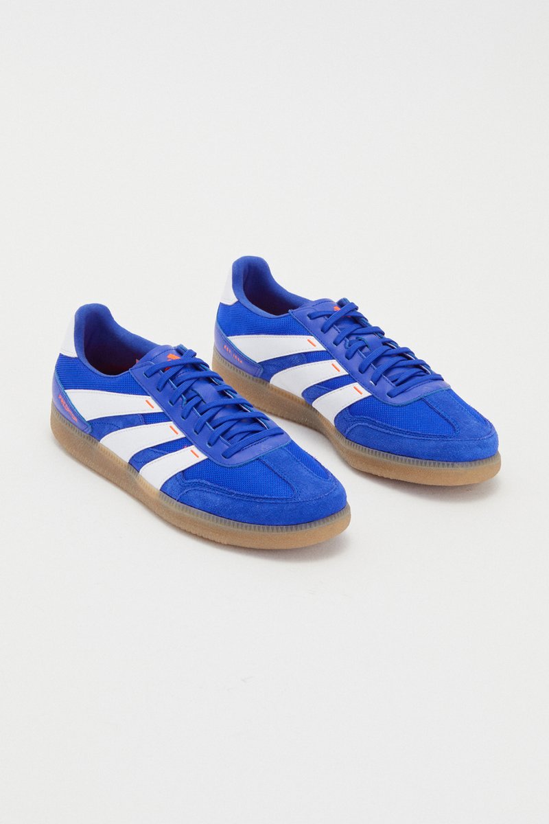 Bright blue trainers with white accents and gum soles, displayed from an elevated angle against a plain white background.