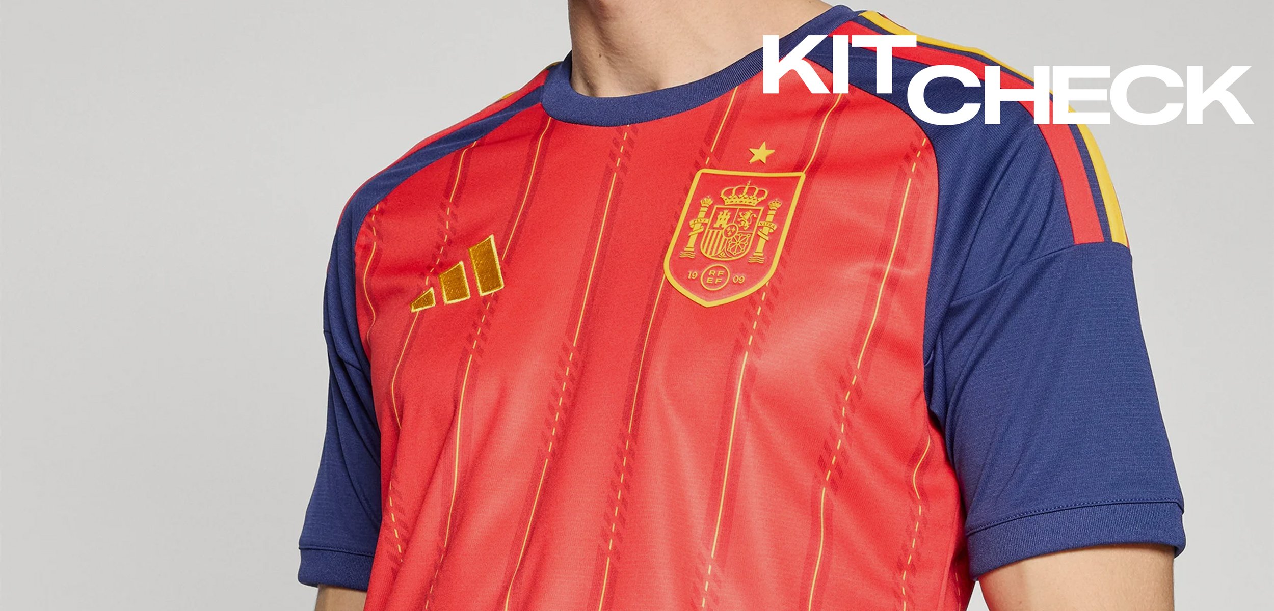 Crveno-plavi nogometni dres Španjolske sa zlatnim Adidas logom i grbom reprezentacije sa zvijezdom iznad na prsima.
