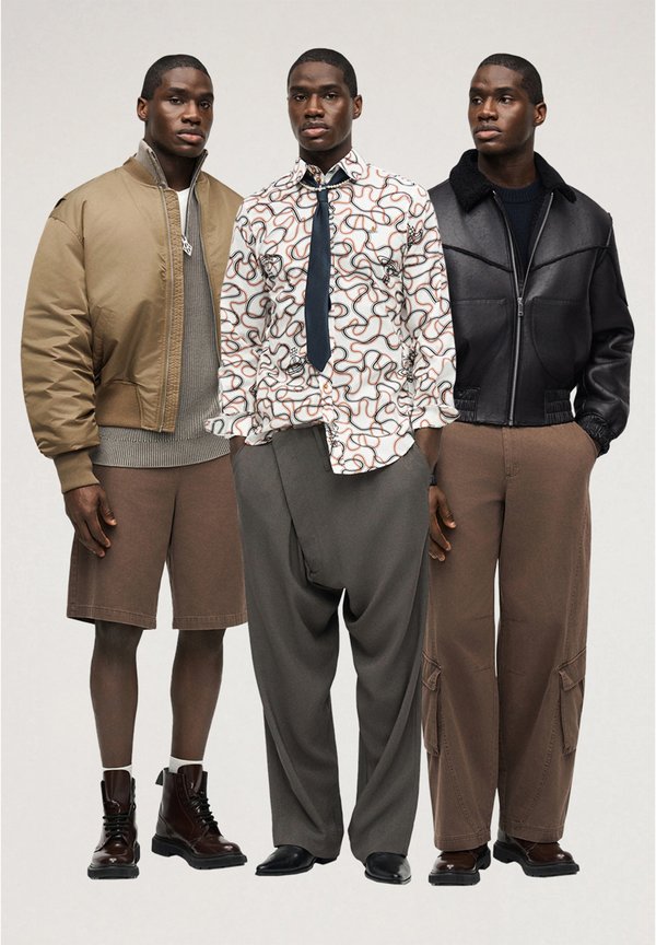 Τρεις άνδρες στέκονται φορώντας στυλάτα ρούχα: μπουφάν bomber με σορτς και μπότες, πουκάμισο με μοτίβα και γραβάτα με φαρδιά παντελόνια, μαύρο δερμάτινο μπουφάν με παντελόνια cargo.