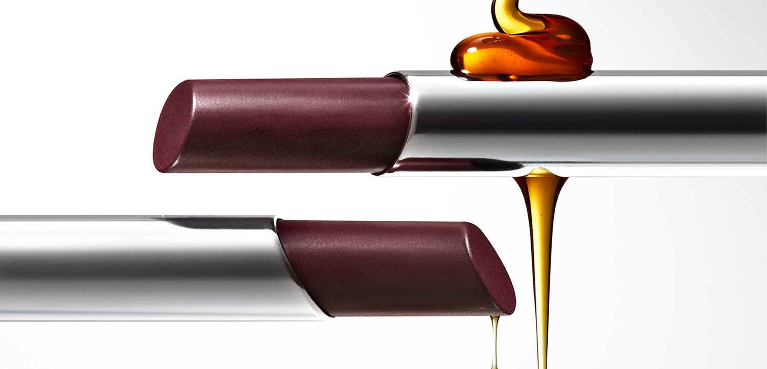 Dunkelburgunderroter Lippenstift mit einer glatten, abgerundeten Form und einer metallisch silbernen Hülse, überzogen mit einer glänzenden, karamellähnlichen Substanz.