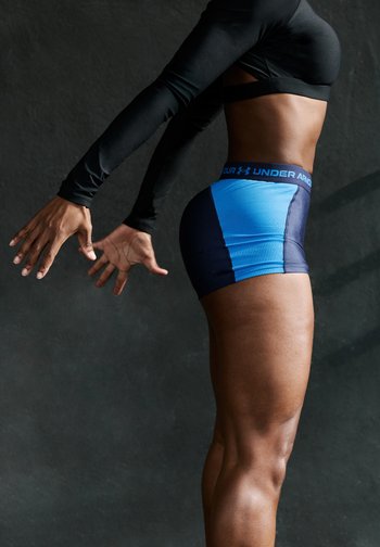 Urheilushortsit sinisessä ja tummansinisessä, joissa on tiukka istuvuus, joustava vyö, jossa on 'Under Armour' -logo, sekä teksturoitu materiaali.