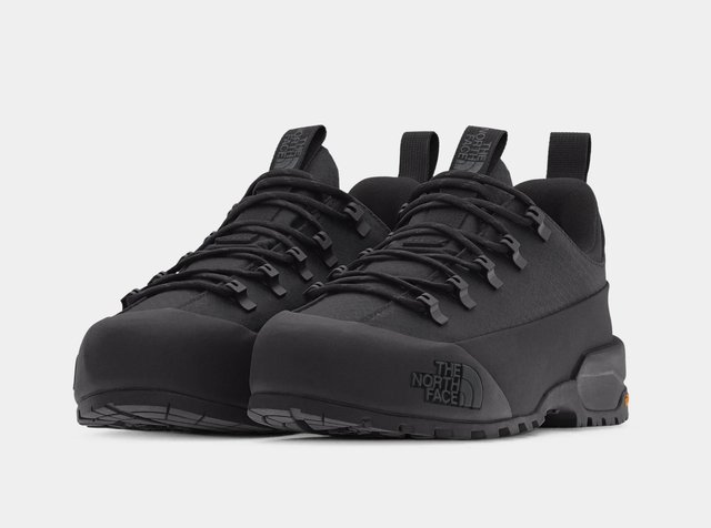 Paire de chaussures de randonnée basses noires avec semelles épaisses et lacets noirs, avec le logo The North Face sur le côté et la languette.
