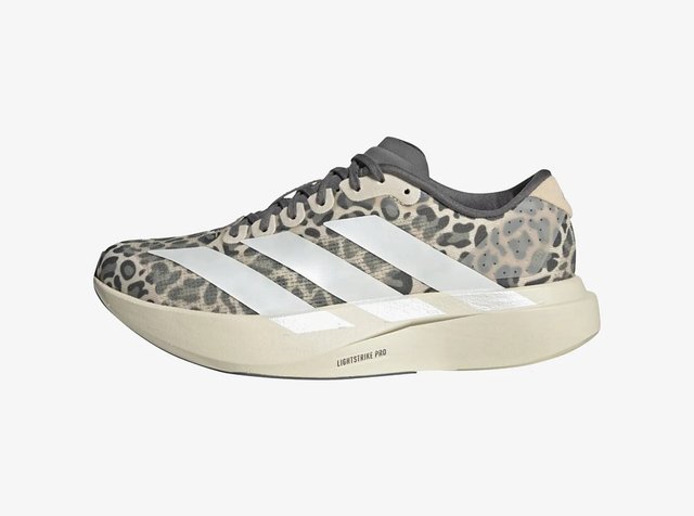 Zapatilla de running con suela beige, parte superior con estampado de leopardo en gris y negro, franjas blancas de Adidas y cordones negros, vista desde el lado derecho.