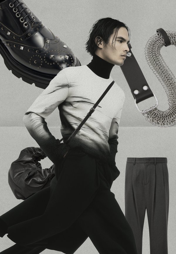 Black leather shoes with studs, a gradient sweater, black trousers, and a textured bag. Features a notable silver chain strap with clips. Monochrome background.