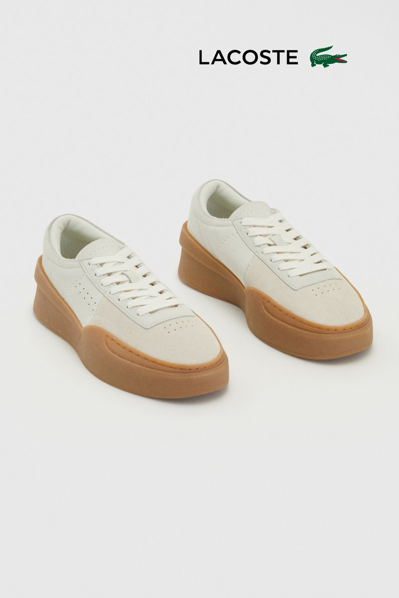 Weisse Leder-Sneaker mit beige Akzenten, runder Spitze, dickem Gummisohle und klassischem Schnürdesign. Strukturiertes Finish.