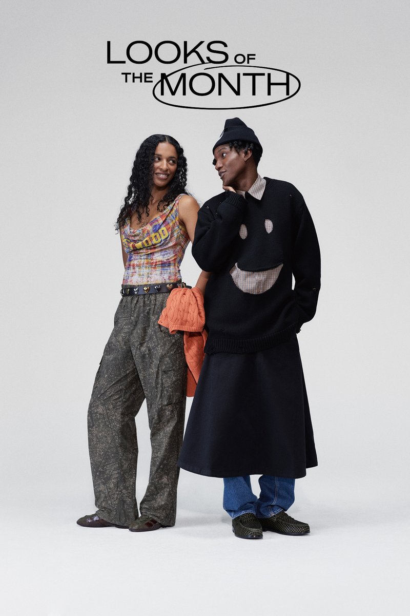 To personer står side om side. Den ene har på seg en flerfarget crop top og kamuflerte cargo-bukser. Den andre har på seg en svart genser med et smilende ansikt.
