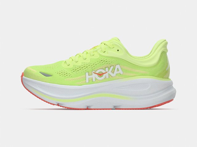 Νεον κίτρινο παπούτσι για τρέξιμο με παχιά λευκή σόλα, πορτοκαλί λεπτομέρειες, επάνω μέρος από δίχτυ και λευκό λογότυπο HOKA στο πλάι.