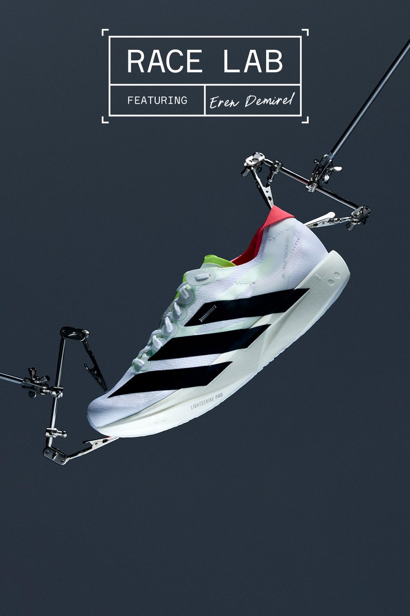 White athletic shoe with black stripes, green and red accents, and a textured upper. Features "LIGHTSTRIKE PRO" on the sole.