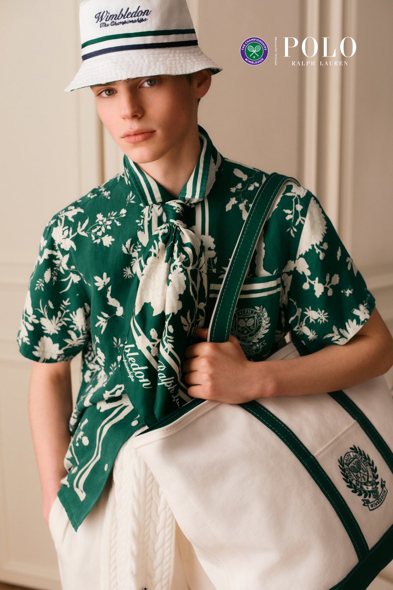 Jeune personne portant un bob blanc de la marque Wimbledon et une chemise verte à fleurs, tenant un grand sac en toile blanc avec une bordure verte.