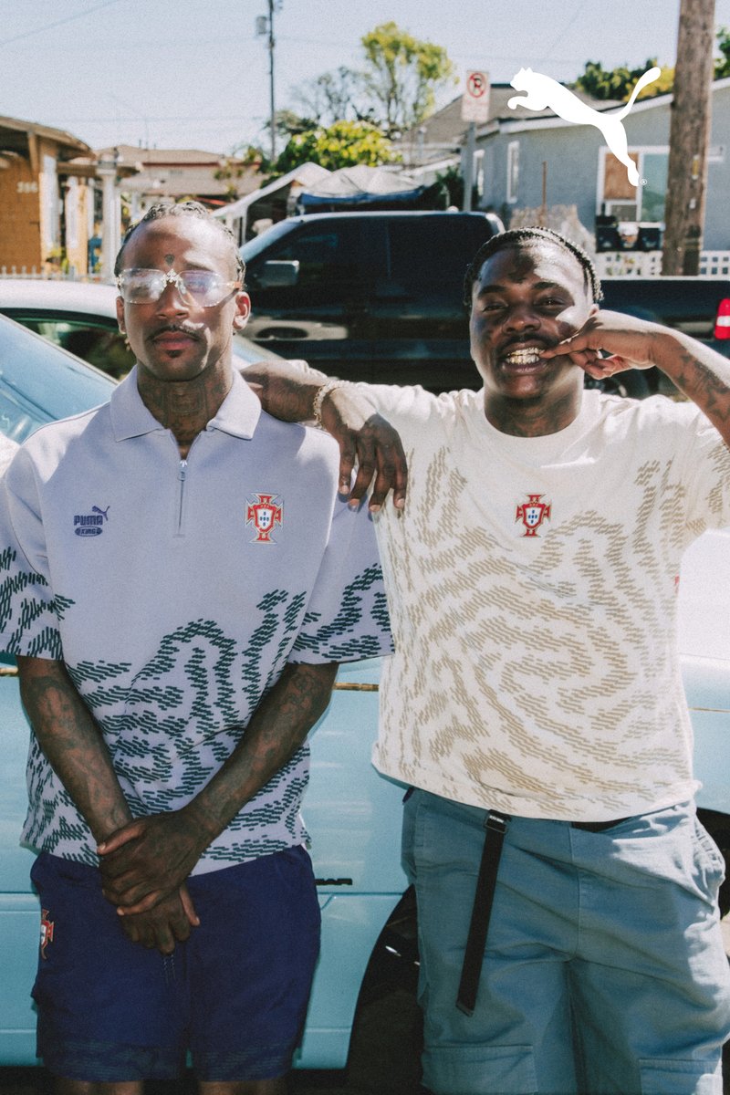 Two men pose casually outdoors wearing Portugal football shirts with Puma logos, one making a hand gesture near his face.