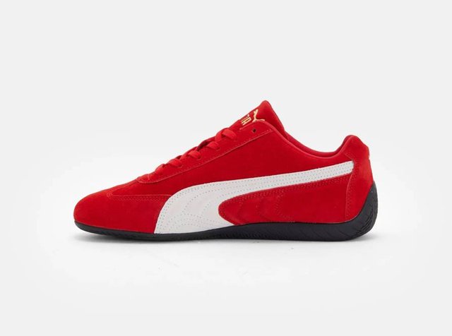 Κόκκινο σουέντ αθλητικό παπούτσι με λευκές δερμάτινες λεπτομέρειες, με μαύρη καουτσούκ σόλα και κόκκινες κορδόνια. Λογότυπο στη γλώσσα. Λείο υφή με μοντέρνο σχεδιασμό.