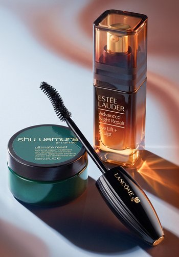 Słoik maski do włosów Shu Uemura, buteleczka serum Estée Lauder Advanced Night Repair i czarna maskara Lancôme ze szczoteczką.