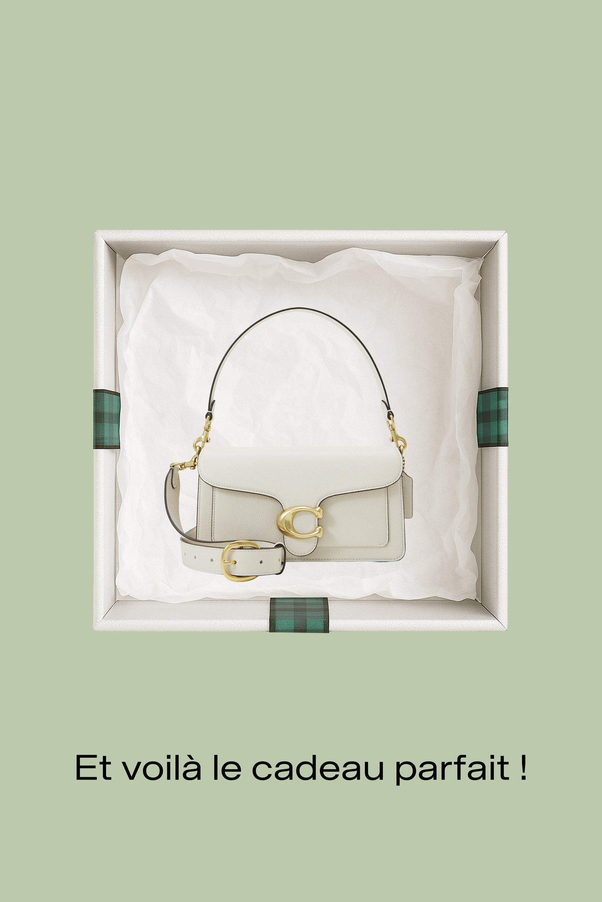 Sac à main en cuir crème avec une sangle amovible, des ferrures dorées et une fermeture distinctive, présenté dans une boîte cadeau avec des accents à carreaux verts.