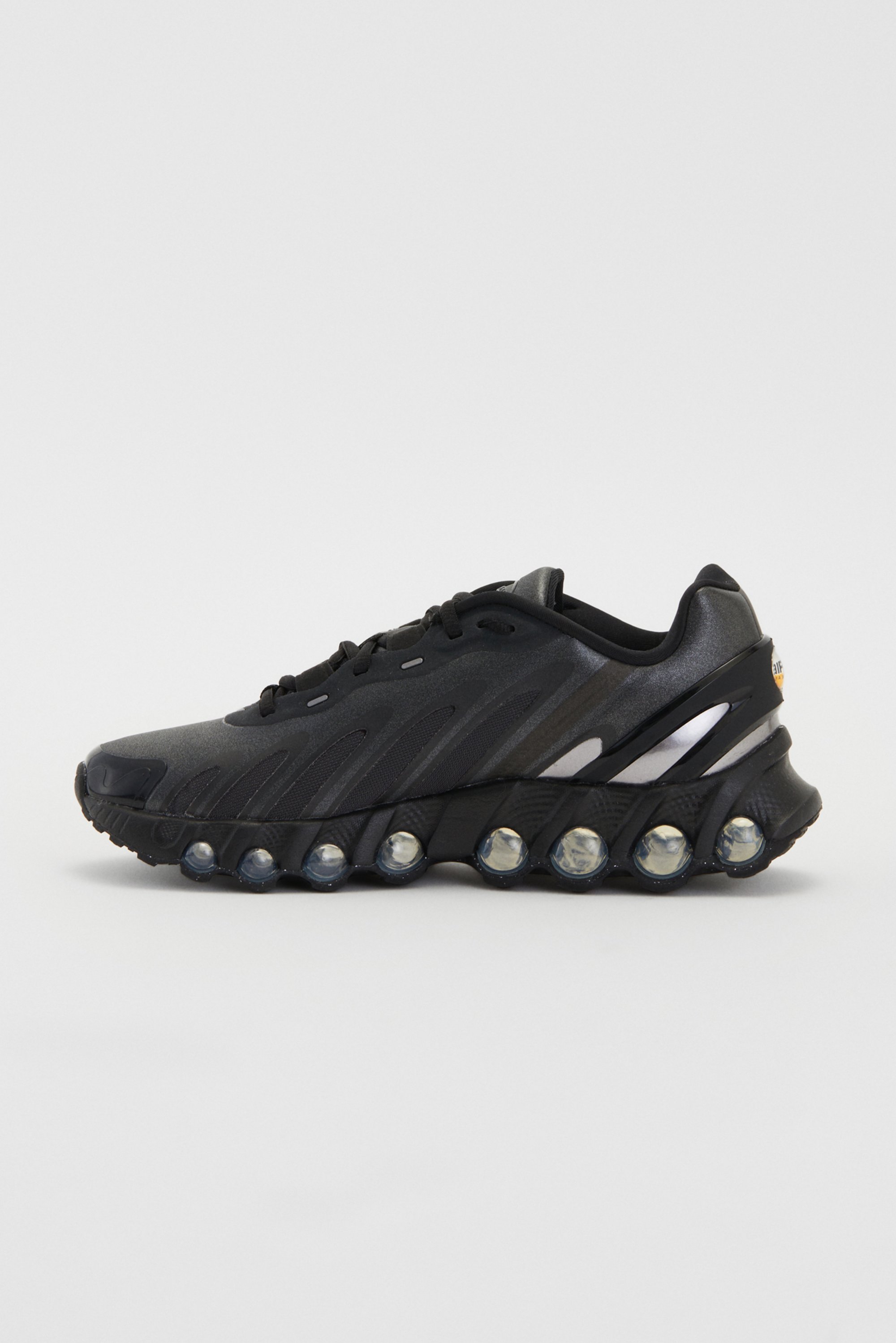 Black athletic sneaker with a sleek design and visible air cushioning along the sole, set against a plain white background.