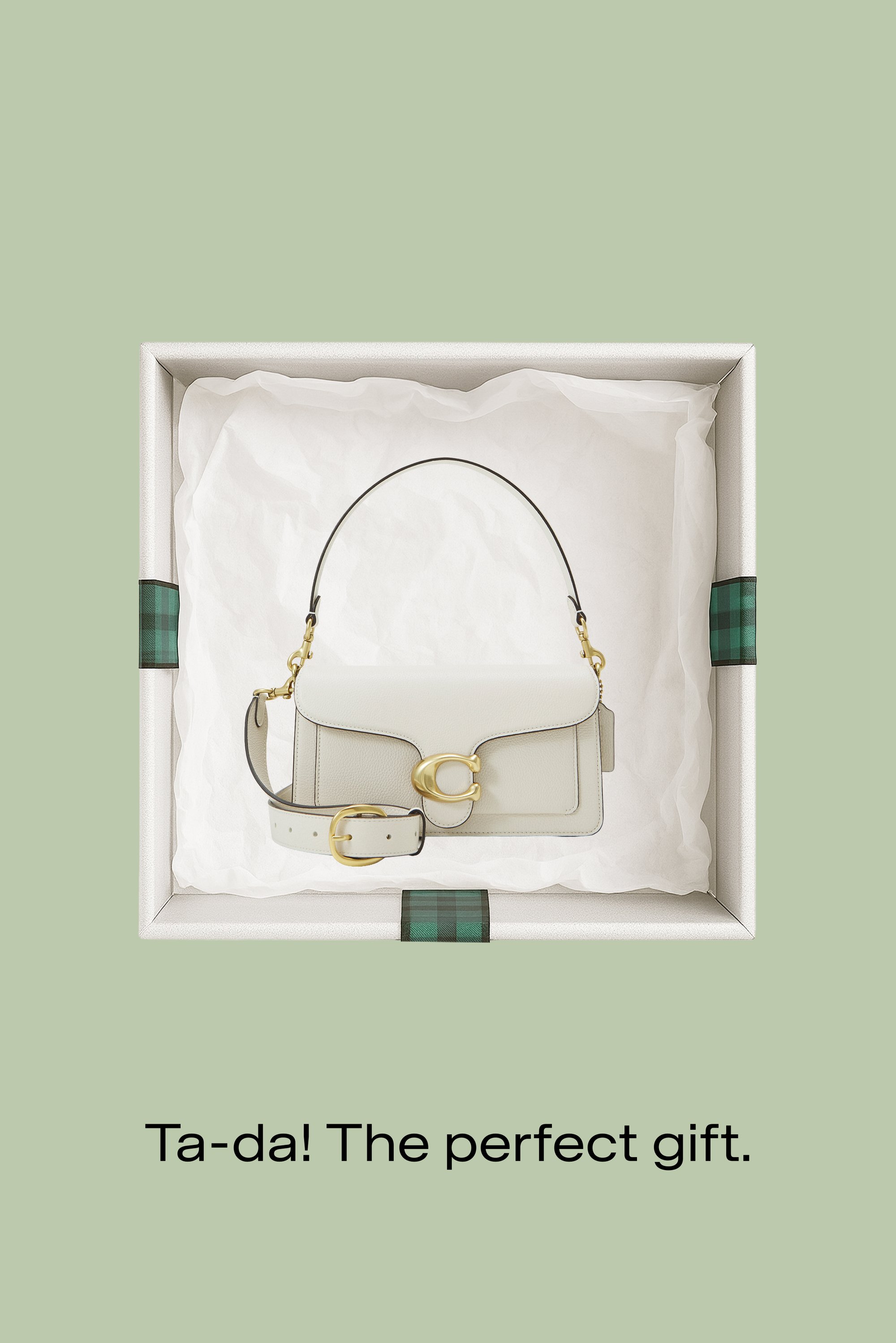 Borsa a mano in pelle bianca con fibbia dorata e tracolla regolabile all'interno di una scatola regalo con carta velina su uno sfondo verde pallido.