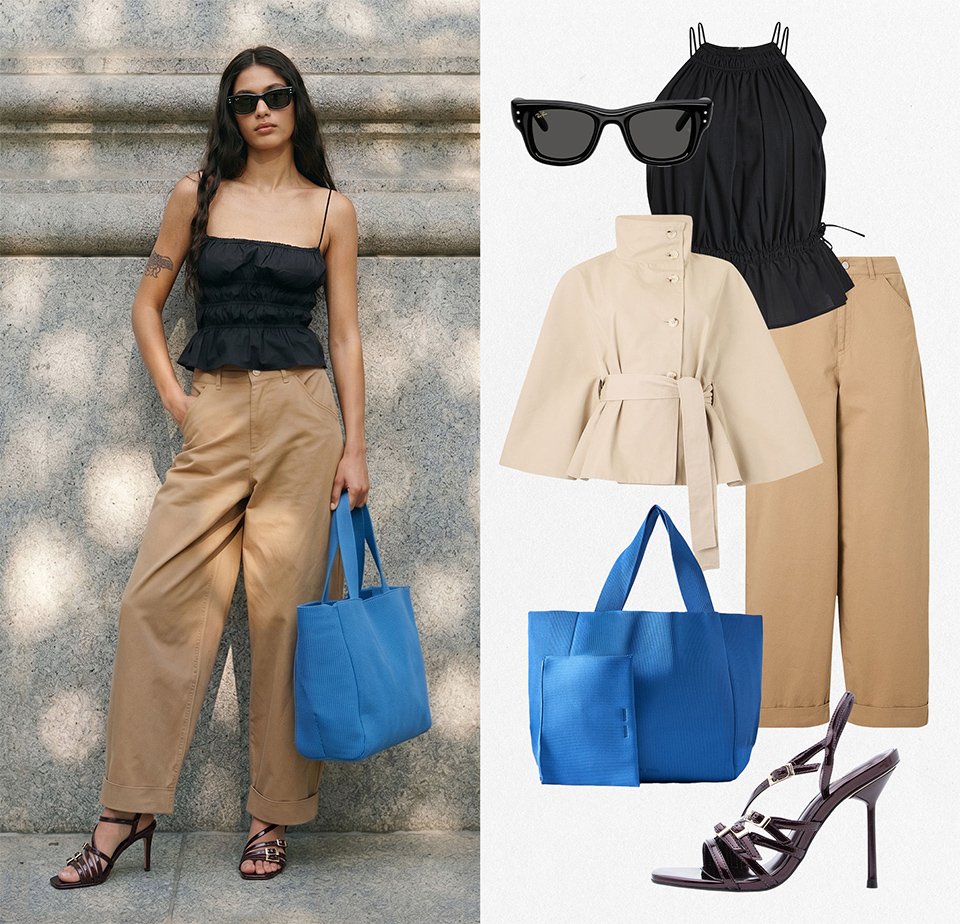 Vrouw draagt zwarte mouwloze top, beige broek met wijde pijpen, zwarte sandalen met bandjes, zonnebril en houdt een felblauwe tote bag tegen een stenen muur.
