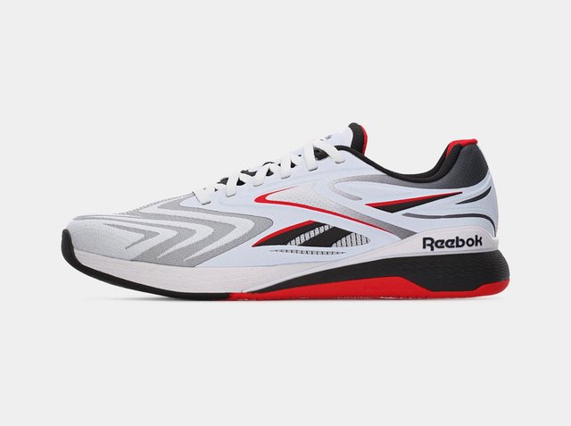 Witte, grijze, zwarte en rode Reebok hardloopschoen met vetersluiting en patroonachtige opdrukken op een effen achtergrond.