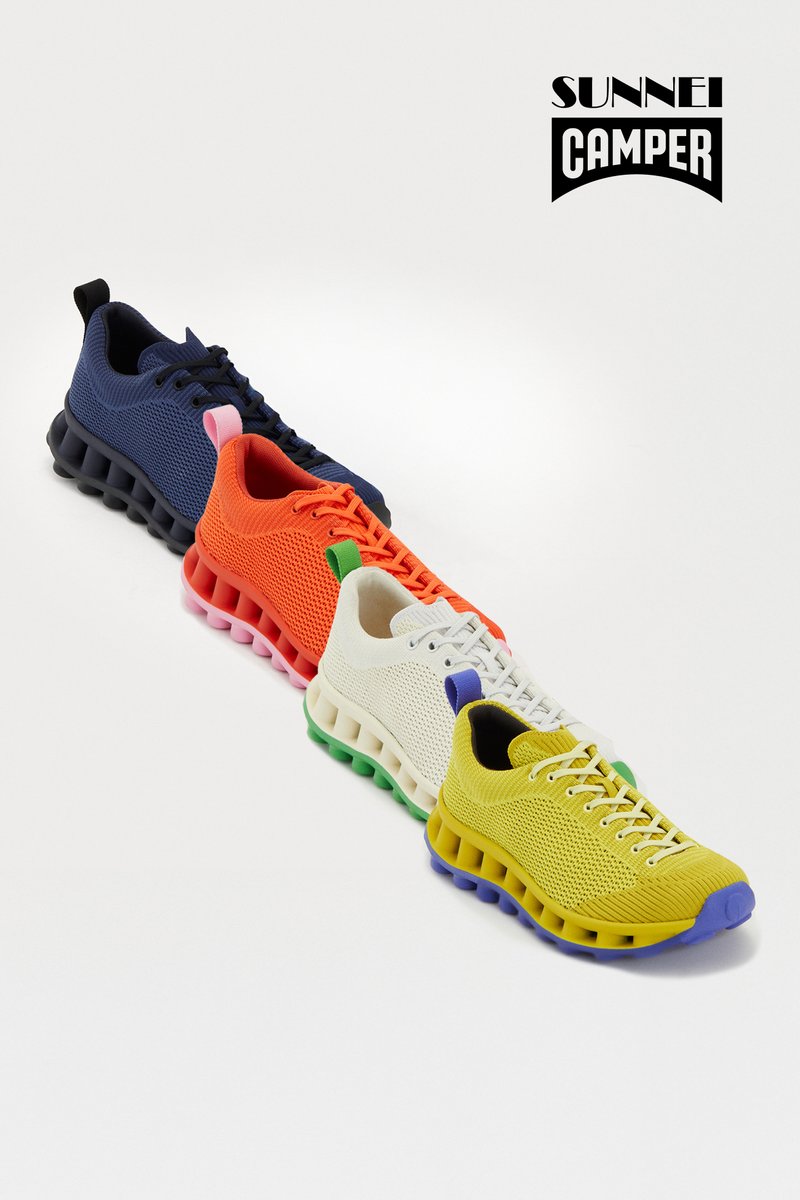 Mehrfarbige Sneakers in Marineblau, Orange, Weiß und Gelb. Mit einem Obermaterial aus Mesh, dickem gepolstertem Sohlen und bunten Akzenten an Ferse und Schnürsenkeln.