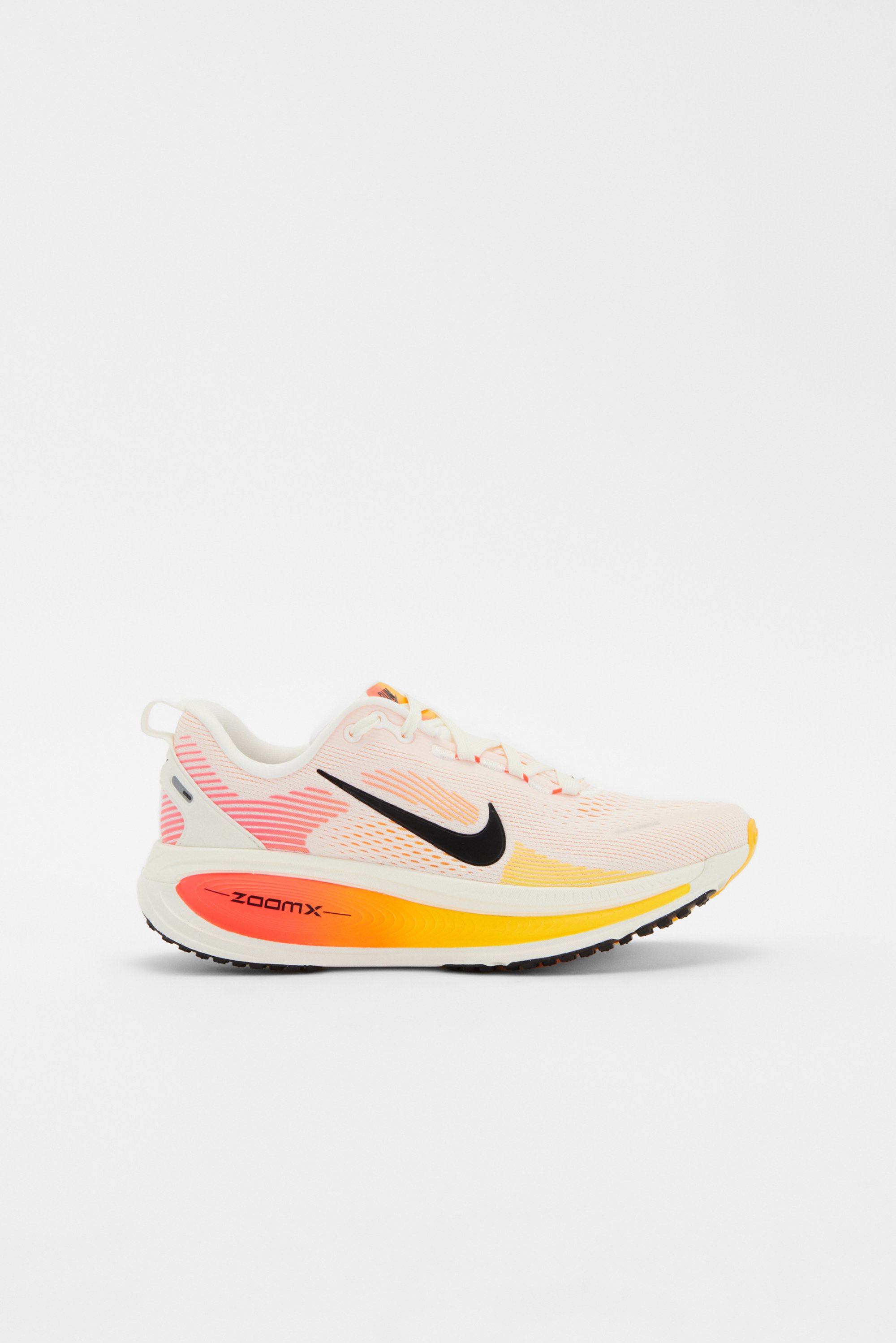 Zapatilla de running Nike en blanco y melocotón con swoosh negro y una vibrante degradado de amarillo a naranja en la suela, diseñada para el rendimiento y la comodidad.