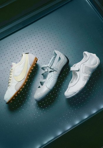Trois chaussures blanches différentes avec des designs distincts placées sur une surface sombre perforée en ligne diagonale.
