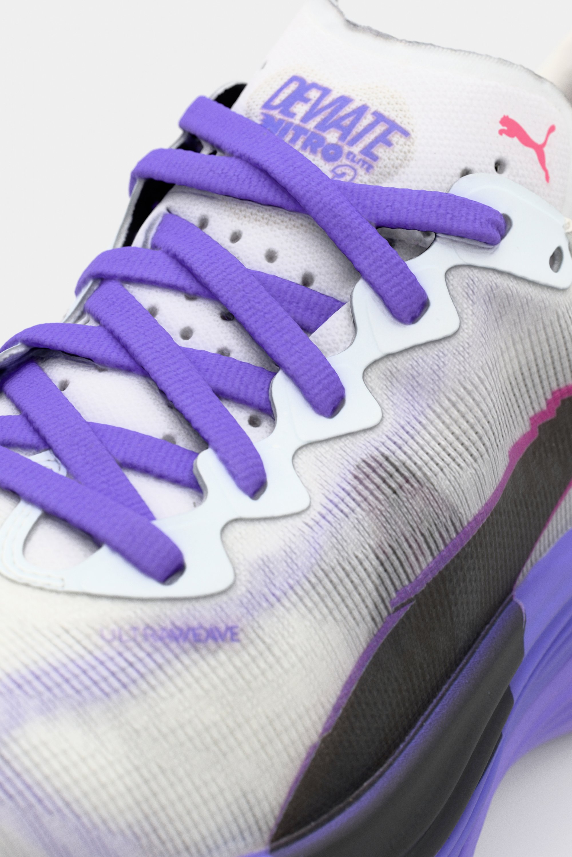 Zapatilla deportiva morada y blanca con parte superior texturizada, que presenta un distintivo sistema de cordones en forma de ondas y un elegante acento negro a lo largo del costado.
