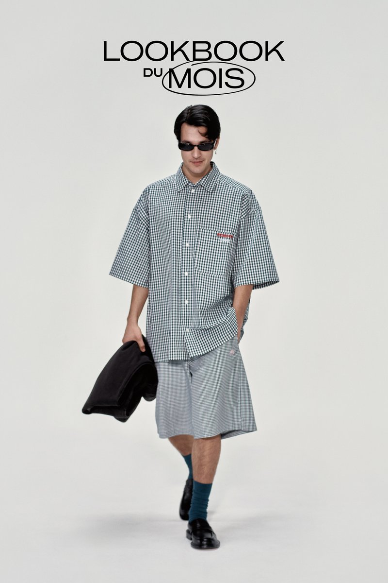 Model in a oversized checkered shirt and shorts, wearing sunglasses, holding a black jacket. Text above reads "LOOKBOOK du MOIS."