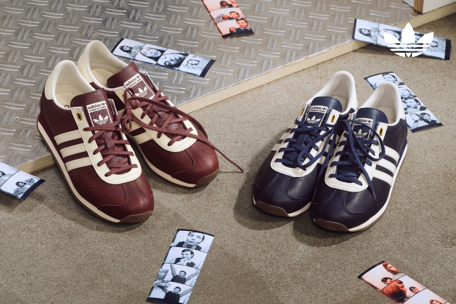 Two pairs of vintage Adidas shoes in burgundy and navy are displayed on a textured surface, surrounded by scattered black-and-white photo strips.