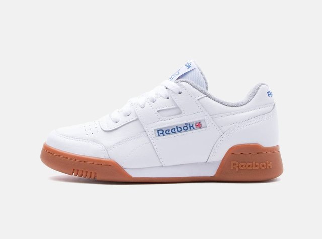 Sapatilha branca Reebok de cano baixo com logótipo azul, biqueira perfurada, pala acolchoada e sola de borracha gum sobre fundo branco.