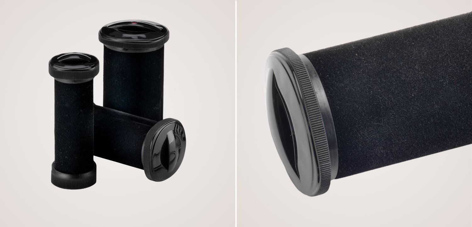 Drie zwarte cilindervormige camerafilmblikjes, waarvan één close-up de getextureerde grip en afneembare dop toont.