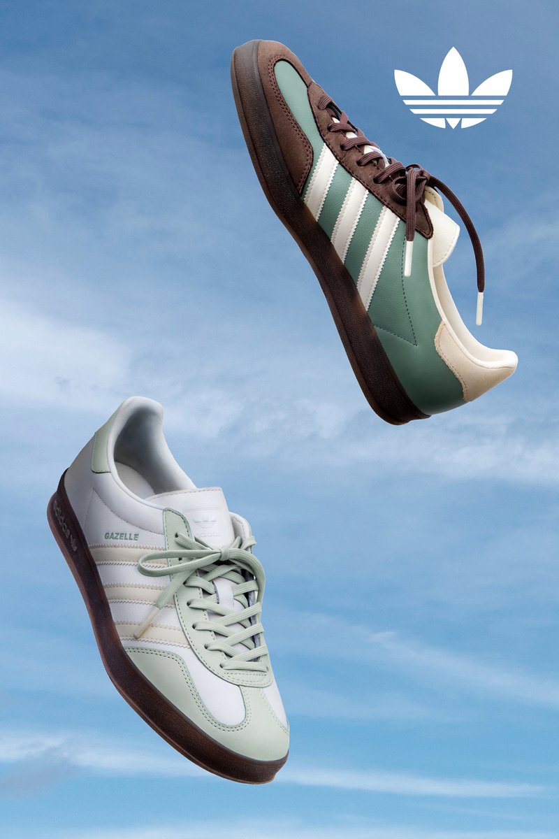 Two pairs of Adidas Gazelle trainers float against a blue sky. One pair is green and brown, while the other is white and light green. The Adidas logo is visible.