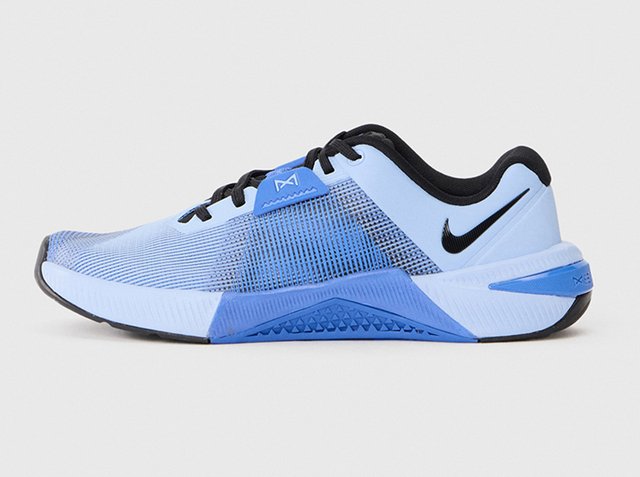 Scarpa sportiva Nike azzurro chiaro e nero con tomaia in mesh, chiusura con lacci e suola testurizzata per allenamento o corsa.