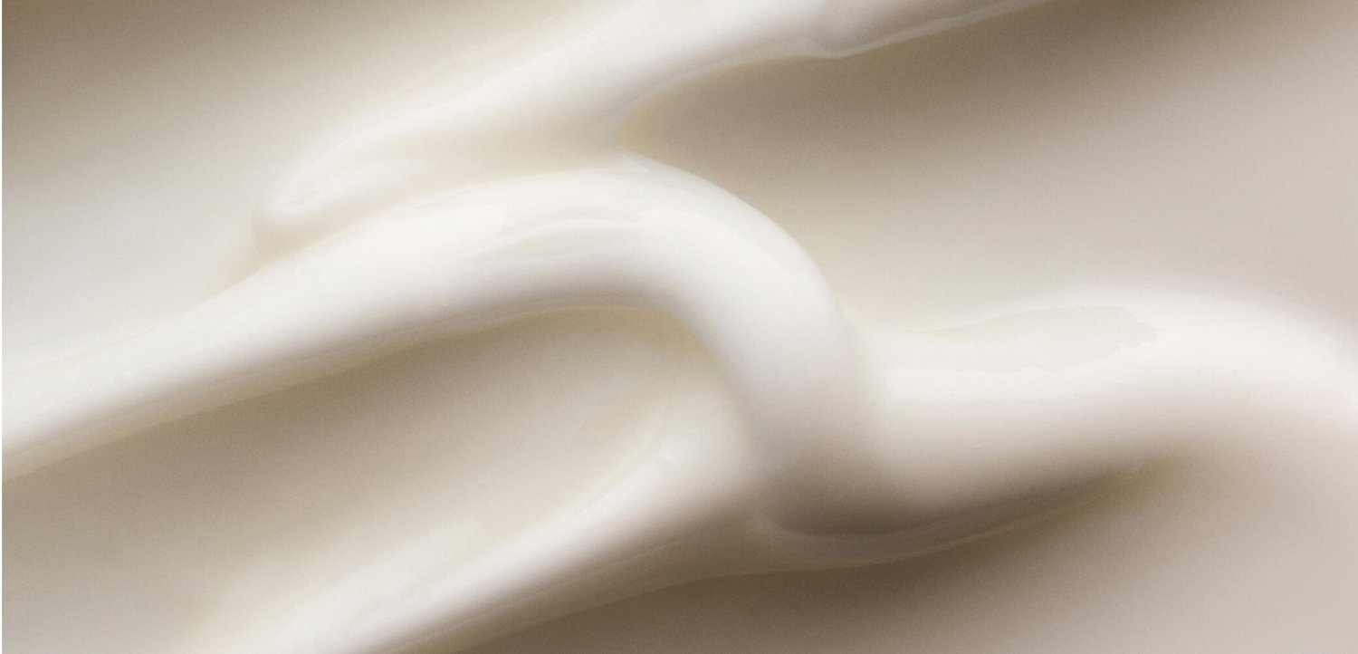 Glatt, cremige weiße Substanz mit weichen Falten und Wirbeln, die der Textur von Lotion oder Creme ähnelt.