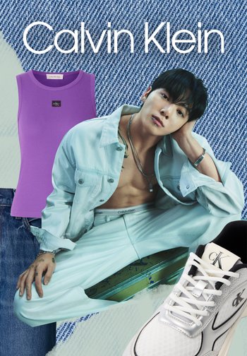 Homme portant une veste en denim clair et un pantalon, posant devant un fond en denim avec un débardeur violet et une basket blanche Calvin Klein présentée.