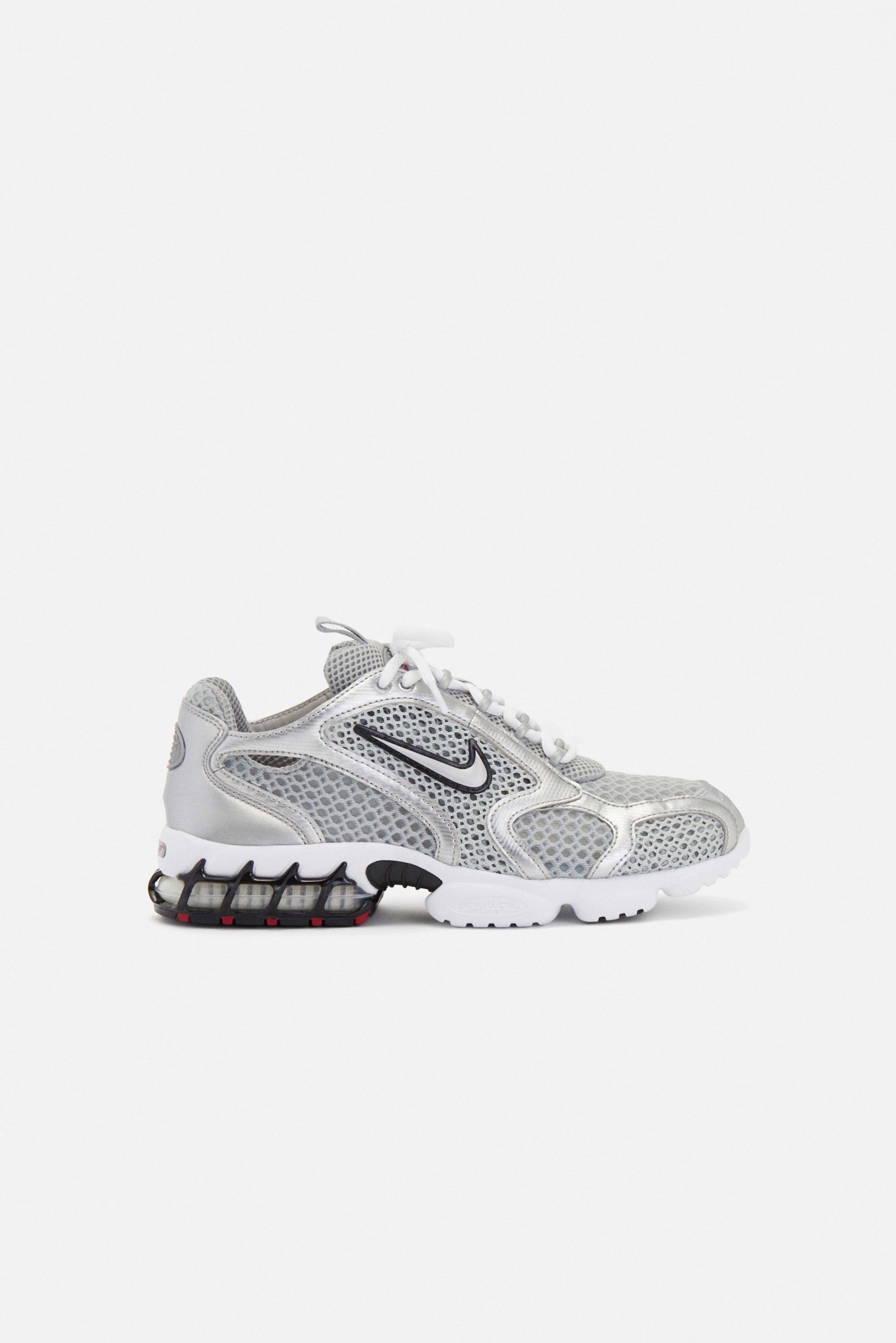 Zilveren en witte sport sneaker met mesh details, zwart swoosh logo en een opvallende gevoerde zool met een zichtbare luchtunit.